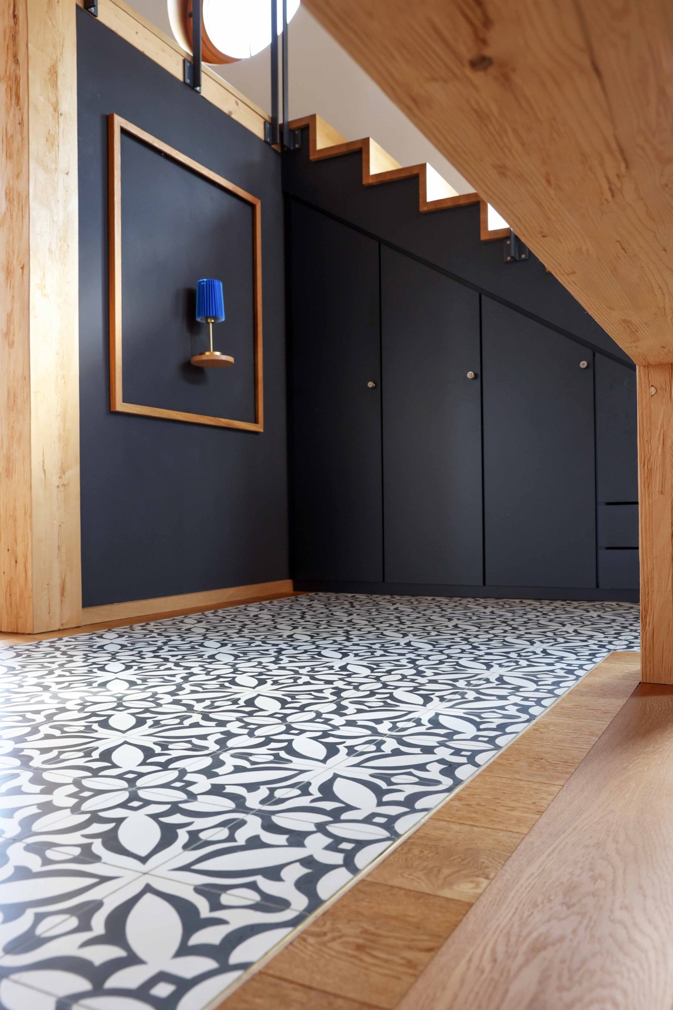 Dunkler Einbauschrank unter einer Holztreppe