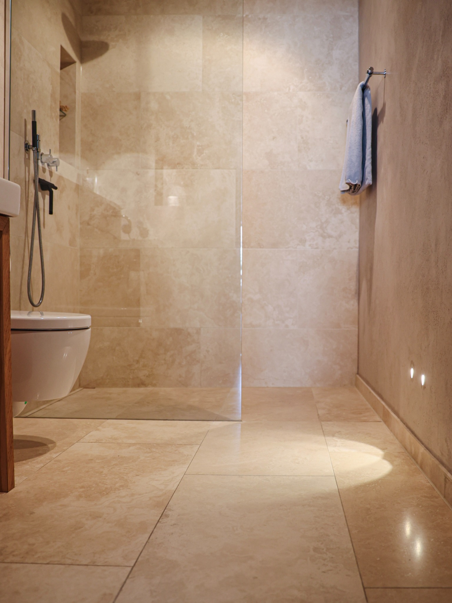 Badezimmer mit bodengleicher Dusche in warmen Naturtönen