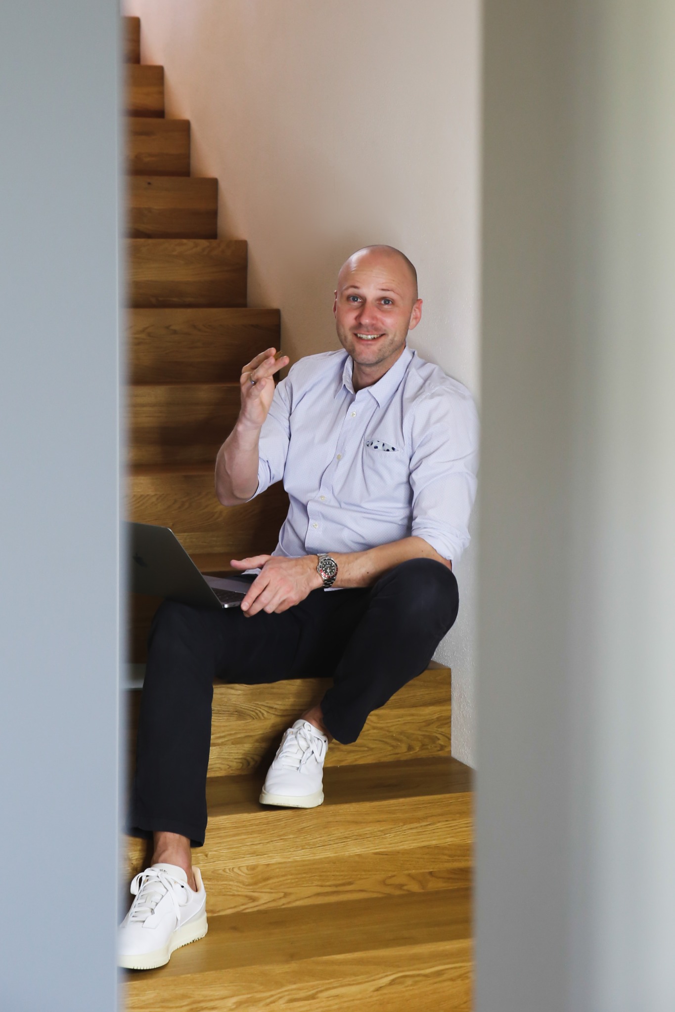Unternehmer sitzt mit Laptop auf einer Holztreppe
