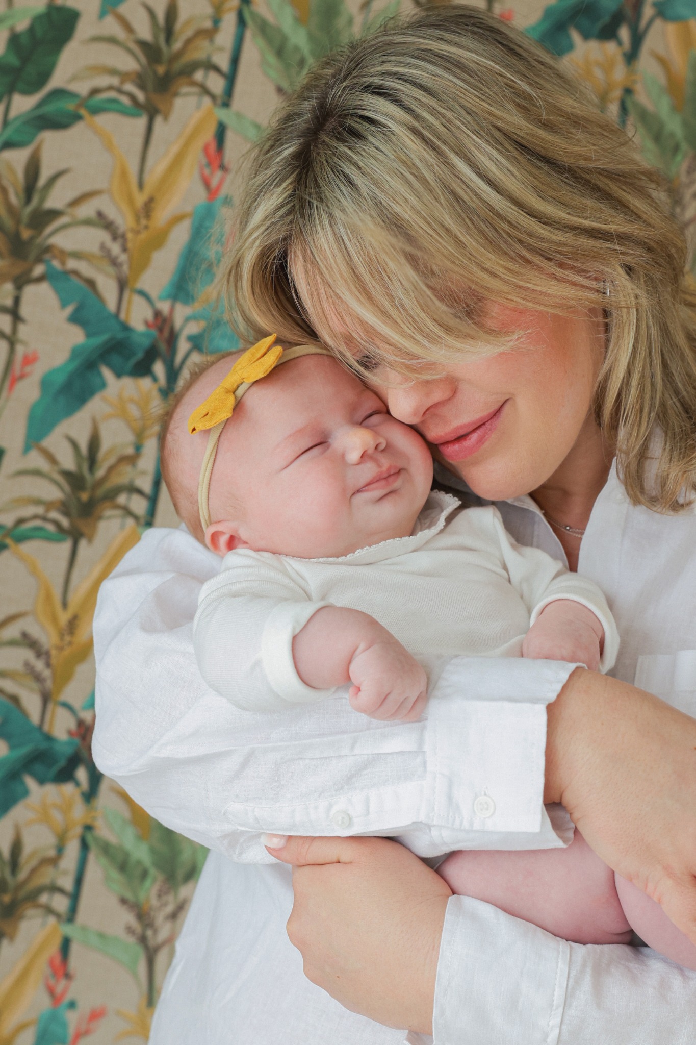 Mutter hält ihr lächelndes Baby zärtlich im Arm