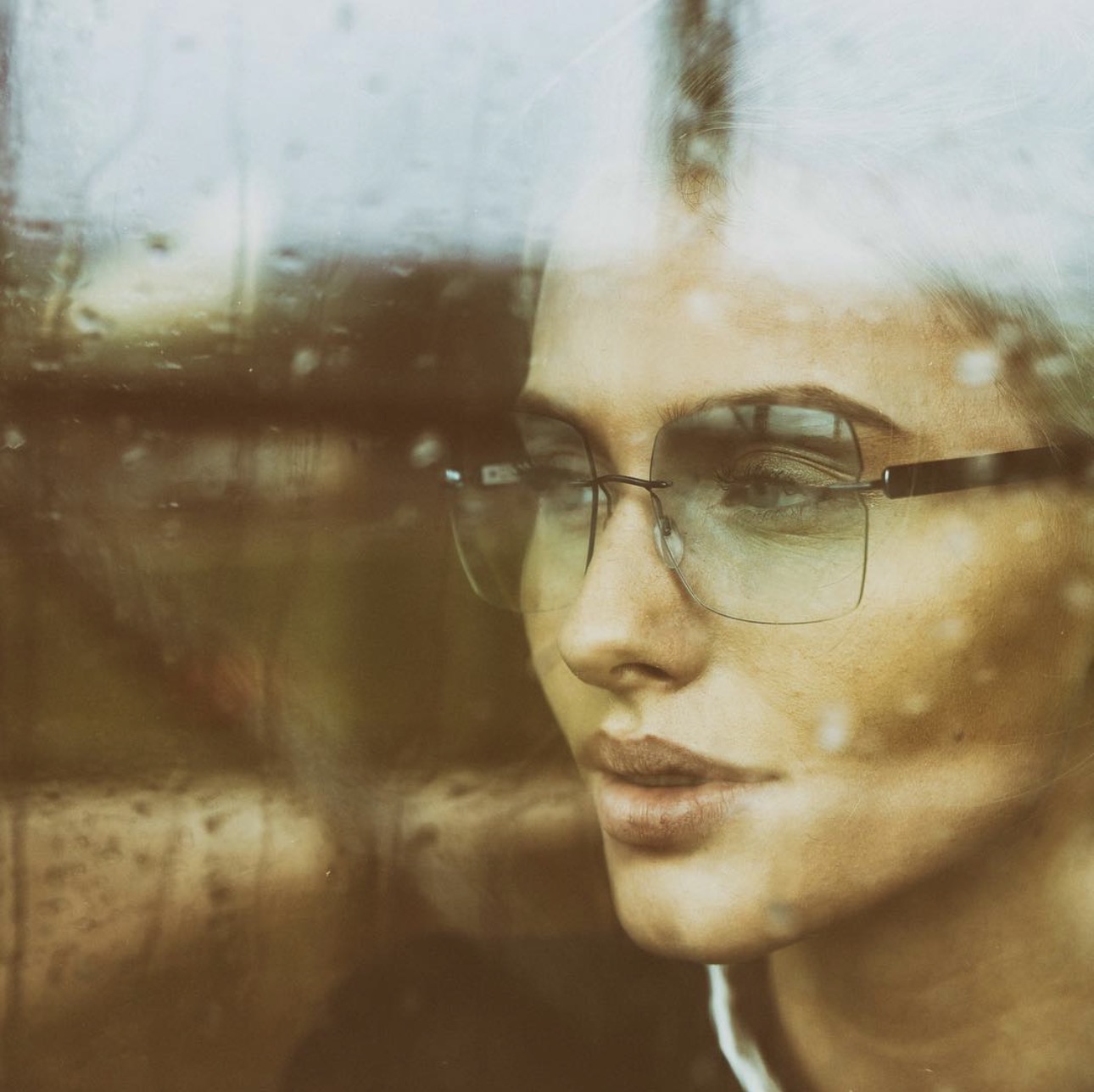 Künstlerisches Portrait einer Frau hinter einer spiegelnden Scheibe