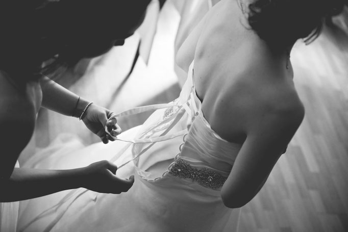 Brautkleid wird beim Getting Ready geschnürt